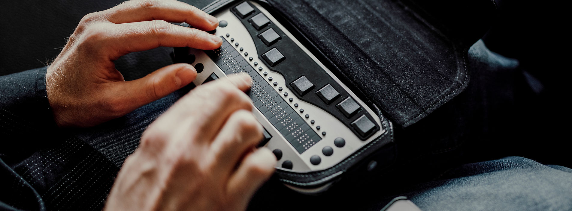 Hands reading a portable refreshable braille display