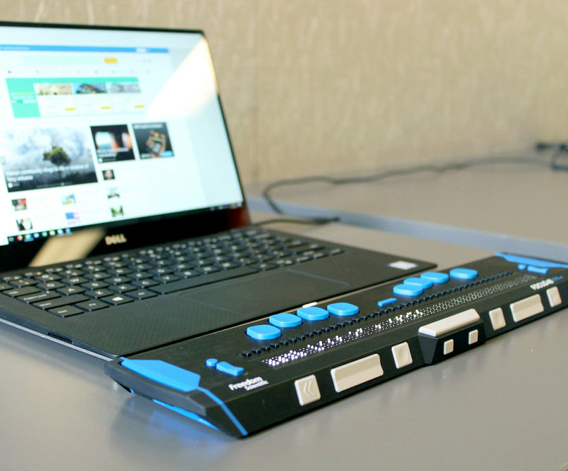 A laptop connected to a refreshable braille display