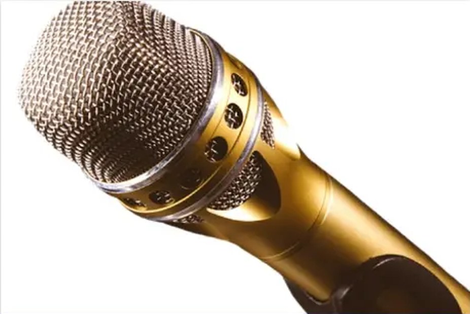 A gold handheld microphone used for voice amplification
