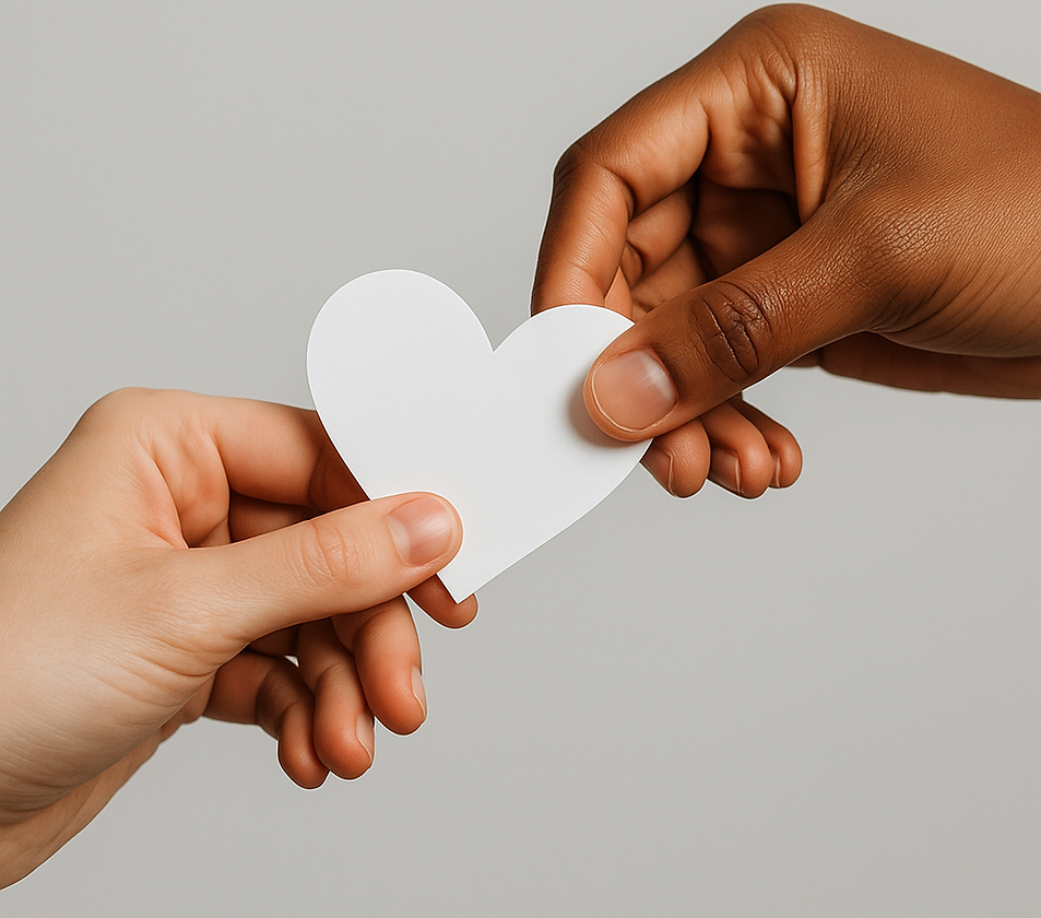 One hand passing a white paper heart to another hand
